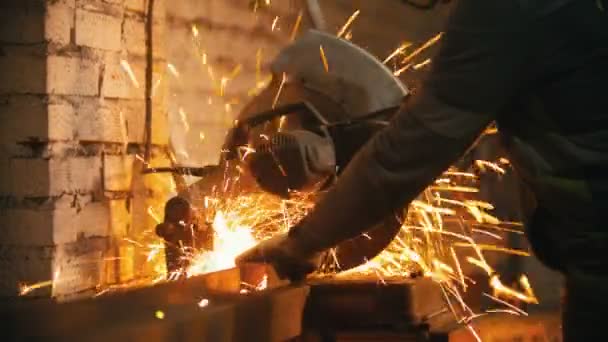 Un homme coupe un morceau de poutre métallique à l'aide d'une grande scie circulaire — Video