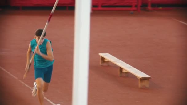 Stabhochsprungtraining im Stadion - ein junger Mann rennt heran und scheitert beim Sprung — Stockvideo