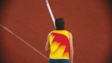 Stadyumda atlama eğitimi alan atletik bir adam.