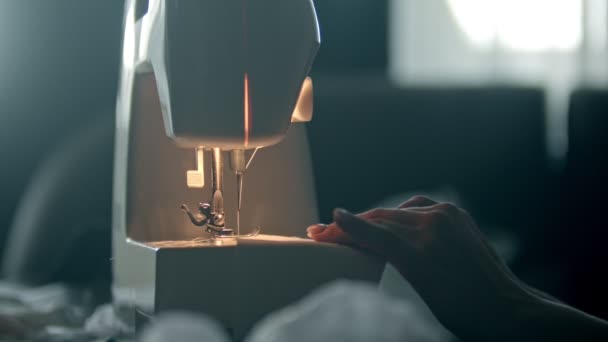 Mains d'une jeune couturière cousant un tissu blanc — Video