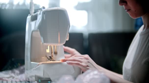 Young woman seamstress sewing a white mask — Stock Video