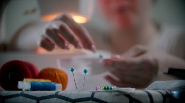 Genç bayan tasarımcı elbise ve rozetlerle çalışıyor.