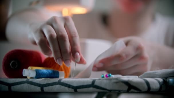 Jonge vrouw ontwerper zetten pinnen in de witte doek voor het naaien — Stockvideo