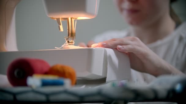 Mujer joven diseñadora cosiendo una máscara reutilizable usando una máquina de coser — Vídeo de stock