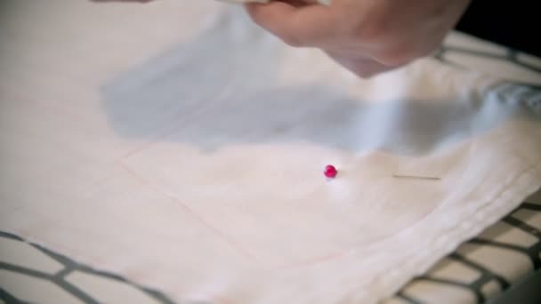 Młoda krawcowa robi ślady mydłem i wkłada szpilki do tkaniny — Wideo stockowe