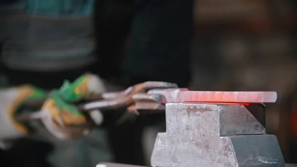 Schmieden eines Objekts aus heißem, längerem Metall mit einer Druckmaschine — Stockfoto