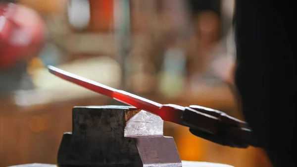 Making a knife out of hot metal using a pressure machine