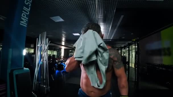 Un bodybuilder homme adulte essuyant son visage avec une serviette et le jetant sur le sol — Video