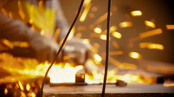 Ein Arbeiter, der mit einem Schleifer Metallbalken halbiert — Stockfoto