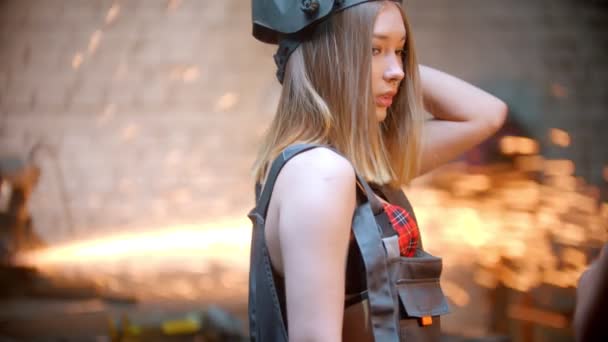 Jong sexy vrouw in rood beha staan in de workshop en zetten op haar helm - poseren voor de camera — Stockvideo