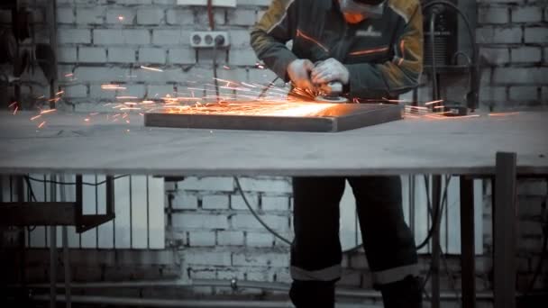 Arbeiter schleifen die Nähte eines Eisengerüstes in der Industriehalle — Stockvideo