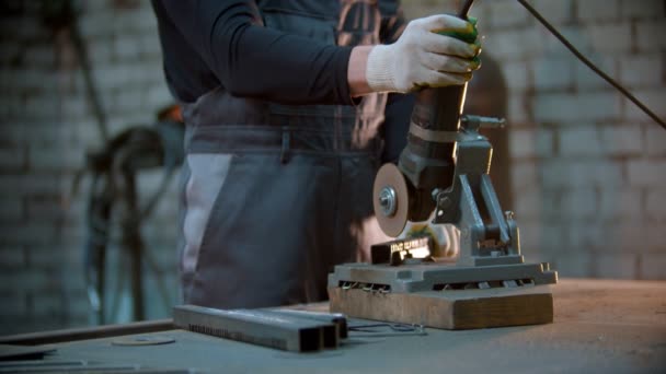 Young man using a grinder to cut the metal detail - sparks comes off the blade — Stock Video