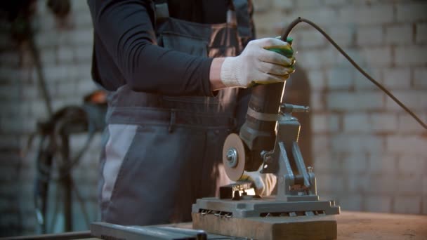 Joven usando una amoladora para hacer muescas en el detalle de metal - chispas sale de la hoja — Vídeos de Stock