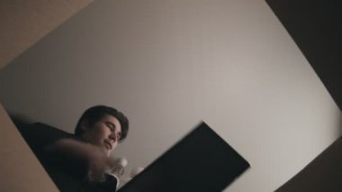 Genç bir adam kutusundan kulaklıklarını ve klavyesini çıkardı.