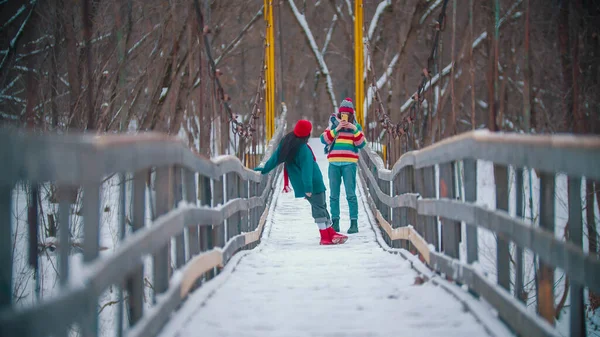 雪の橋で写真を撮る2人のカラフルな女性 — ストック写真