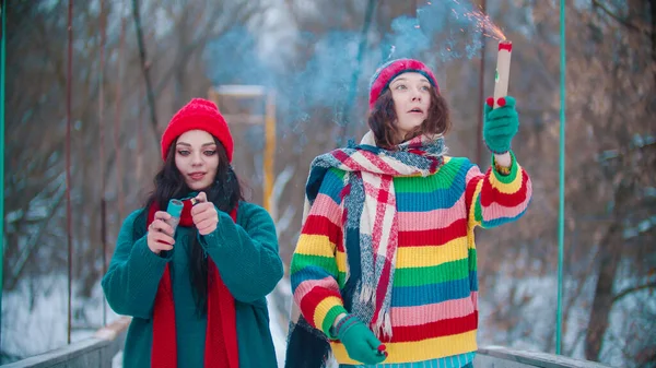 Två kvinnor tänder rökbomber på vinterbron — Stockfoto