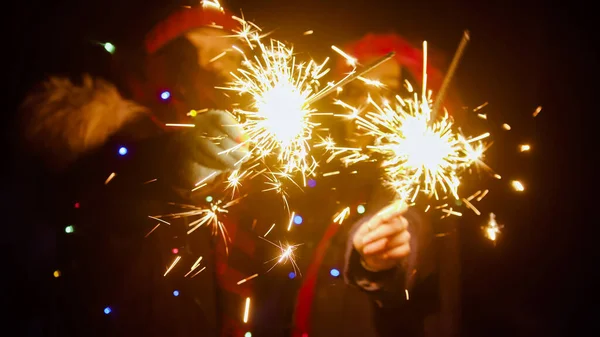Young women friends holding bright sparklers at night — Stock Photo, Image