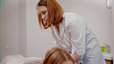 Masaj - kızıl masaj ustası dolaptaki genç bir kadına masaj yapıyor.