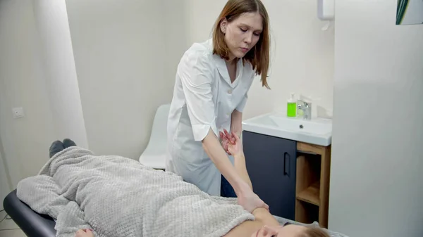 Massageterapeuten knådar en kvinnas händer. — Stockfoto