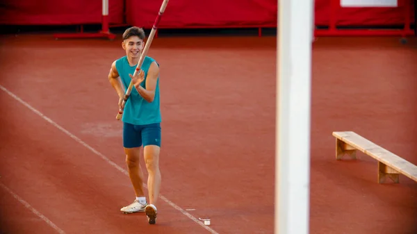 Pole vault training on the stadium - a young smiling man preparing before the jump — Stock Photo, Image