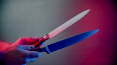 Neon ışıkta bıçakları keskinleştiren biri.