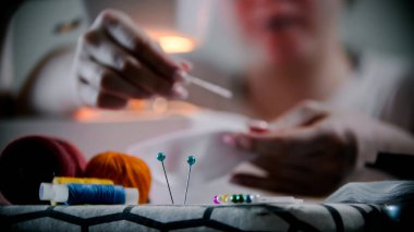 Genç bayan tasarımcı elbise ve rozetlerle çalışıyor.