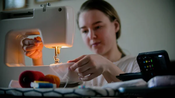 Mujer joven diseñador de costura máscara decorativa utilizando una máquina de coser —  Fotos de Stock