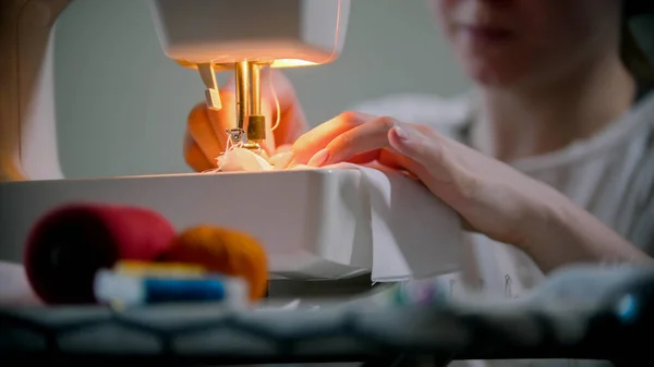 Mujer joven diseñadora cosiendo una máscara reutilizable usando una máquina de coser —  Fotos de Stock