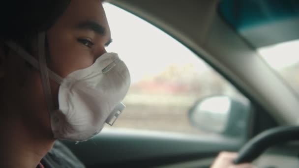 Joven con máscara protectora conduciendo un coche con mal tiempo nublado — Vídeos de Stock