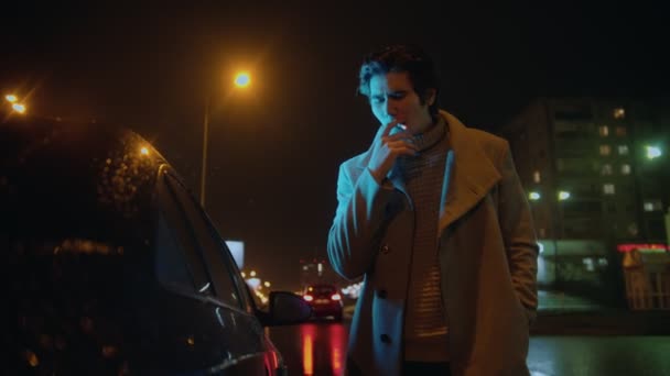 Joven hombre con estilo de pie cerca de su coche y fumar cigarrillos al aire libre — Vídeos de Stock