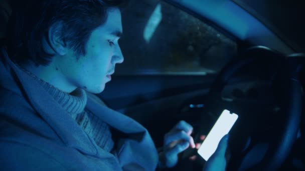 Jóképű férfi ül a kocsiban és mobiltelefont használ. — Stock videók