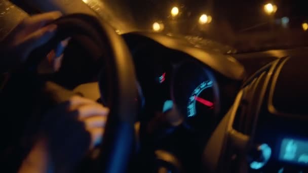 Jonge man die 's nachts een auto bestuurt - stuur vasthouden — Stockvideo