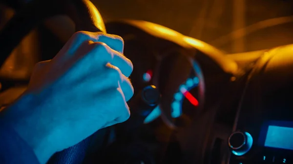 Jovem dirigindo um carro à noite - segurando o volante — Fotografia de Stock