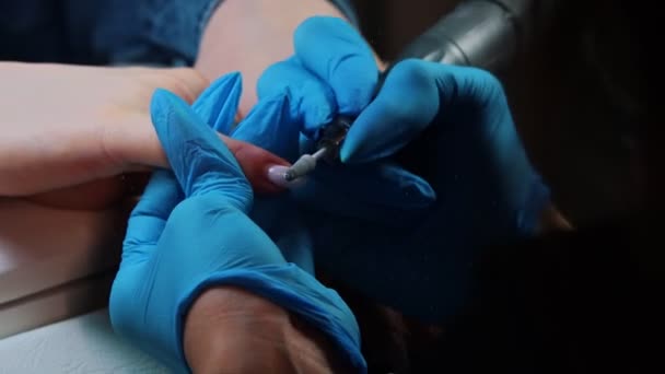 Мастер маникюра удаляет старое покрытие с ногтей — стоковое видео