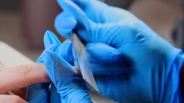 Manikúra mistr v rukavicích dělá manikúru - pilování nehtů — Stock video
