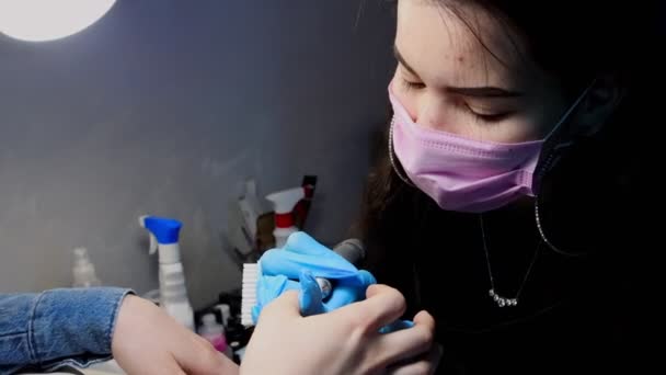 Maître manucure en masque rose et gants bleus faisant manucure matérielle — Video