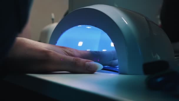 Hand of young woman in UV lamp with blue light gel polish manicure — Stock Video