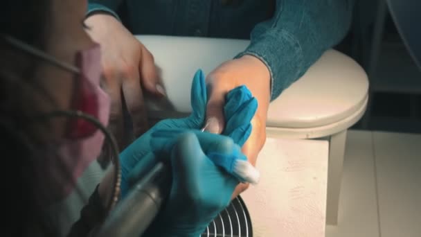 El maestro de la manicura en la máscara que hace la manicura - limpia la cutícula usando el dispositivo — Vídeo de stock