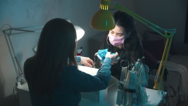 Manikyr mästare i mask och handskar gör manikyr - rengör nagelbanden med hjälp av enheten — Stockvideo