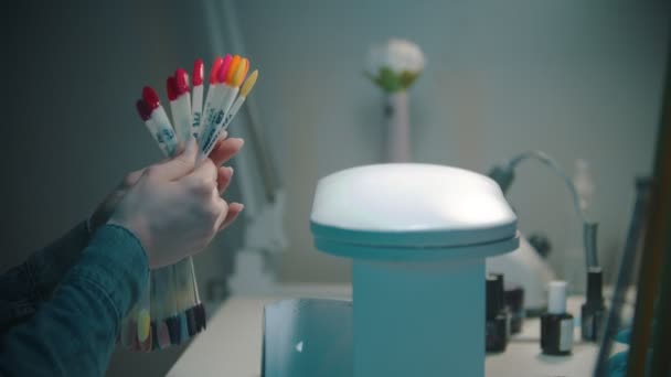 Mujer joven eligiendo el color cálido del esmalte de uñas en las muestras — Vídeos de Stock