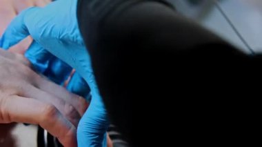 Manikür ustası manikür yapıyor. Güzellik salonunda tırnaklarını törpülüyor.