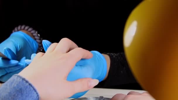 Doing manicure in blue gloves - filing the nails with nail file — Stock Video