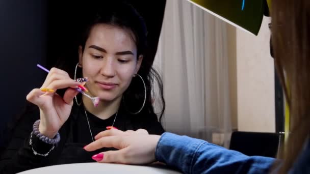 Manicure doen in schoonheidssalon - glitters aanbrengen op de roze nagel — Stockvideo