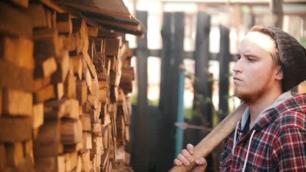 Jongeman houthakker met bijl zet het hout van de standaard — Stockvideo