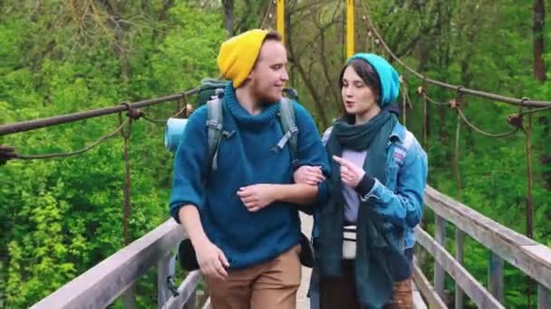 Jeune homme et jeune femme marchant sur le pont — Video