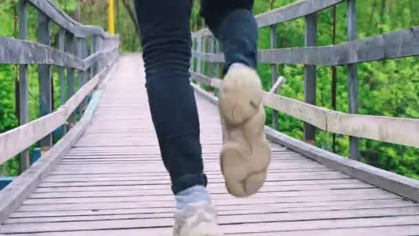 Jeune homme courant sur le pont - l'homme s'arrête pour attacher ses chaussures — Video