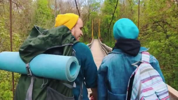 Ung man och kvinna går på bron och pratar på varandra — Stockvideo