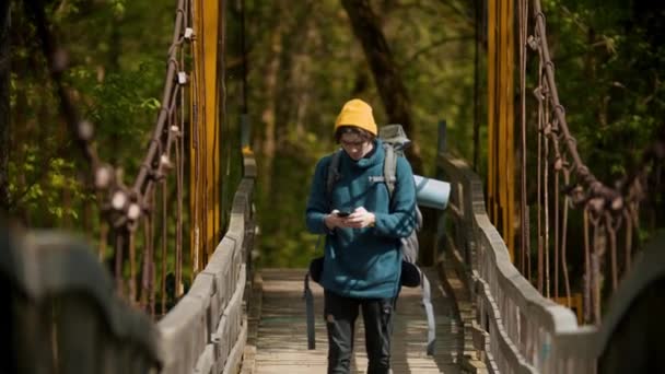 Jeune homme voyageur debout sur le pont et essayant de trouver un réseau — Video