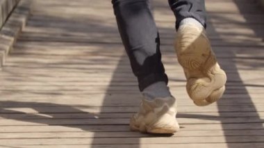 Köprüde koşan büyük sırt çantalı genç adam.