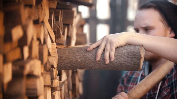 Young man putting logs in the stand — Stock Photo, Image